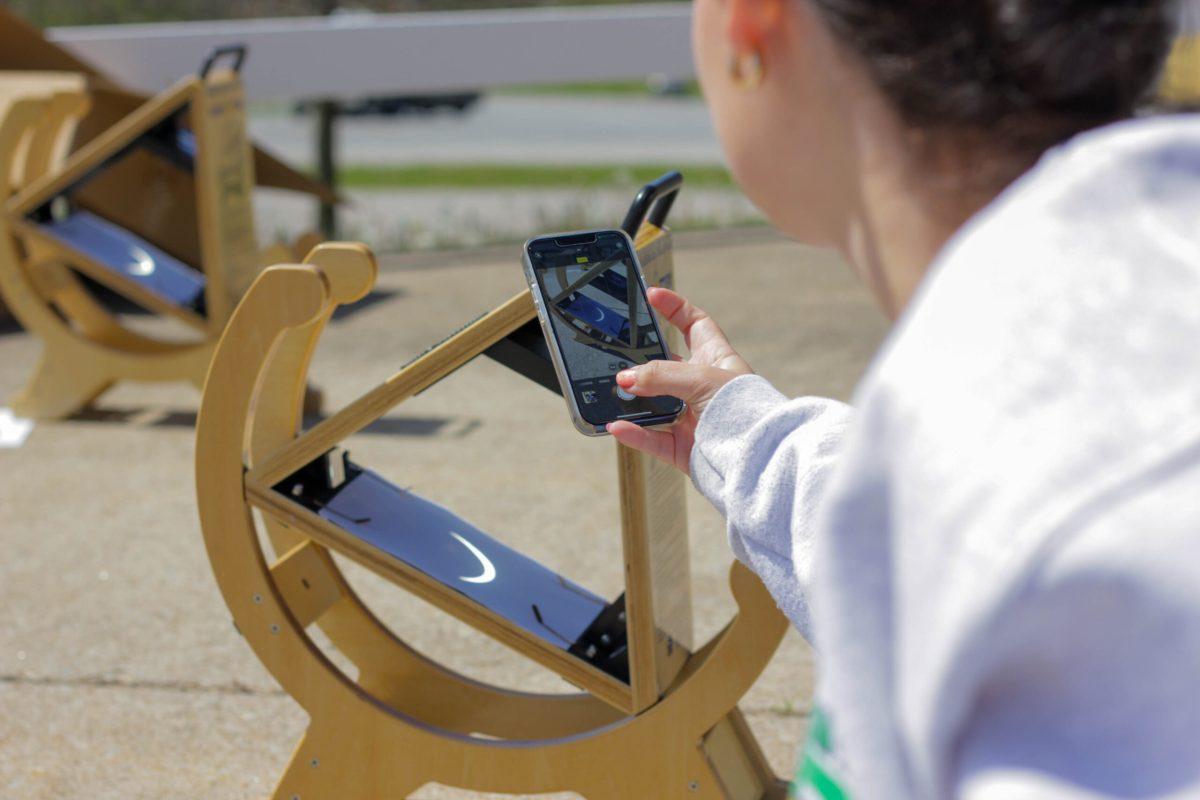 Girl taking a picture of eclipse’s shadow on the sunspotter
