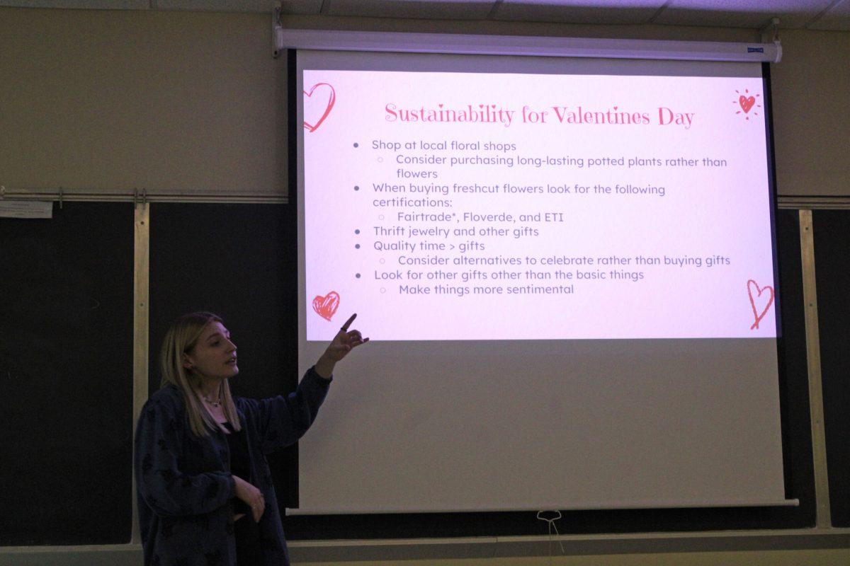 Girl stands in front of slideshow screen giving presentation.