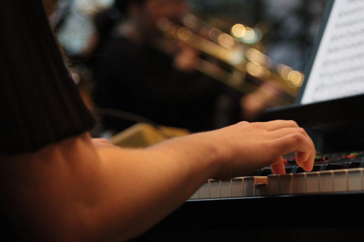 Jazz pianist plays keyboard during concert.