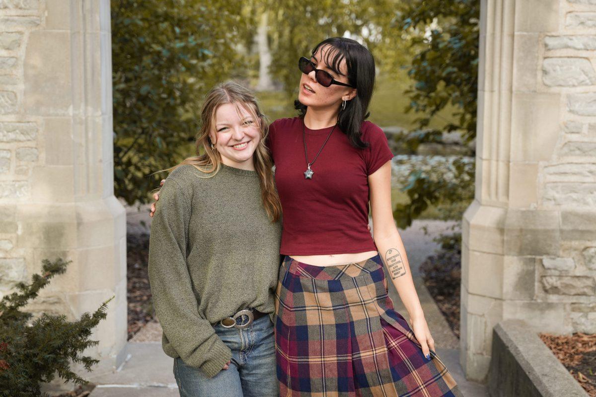 Two girls standing with their arms around each other.