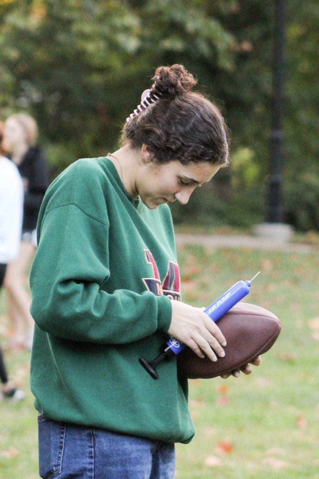 A student trying to add air into a football.