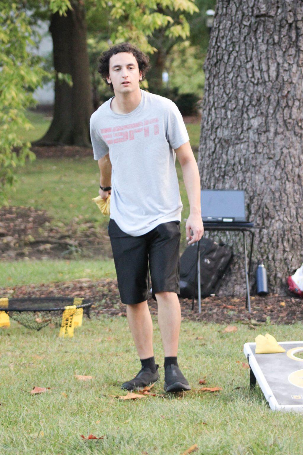A student playing bags in the park.