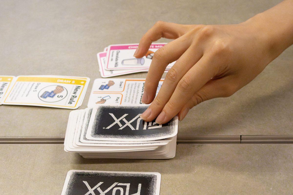 A hand drawing a card from the top of a card pile.