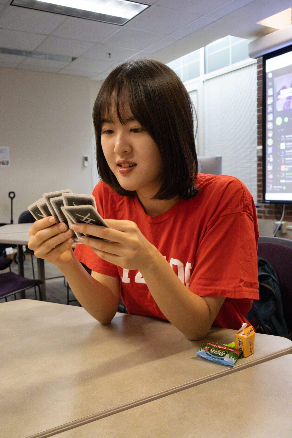 A student looks at six cards in their hands.