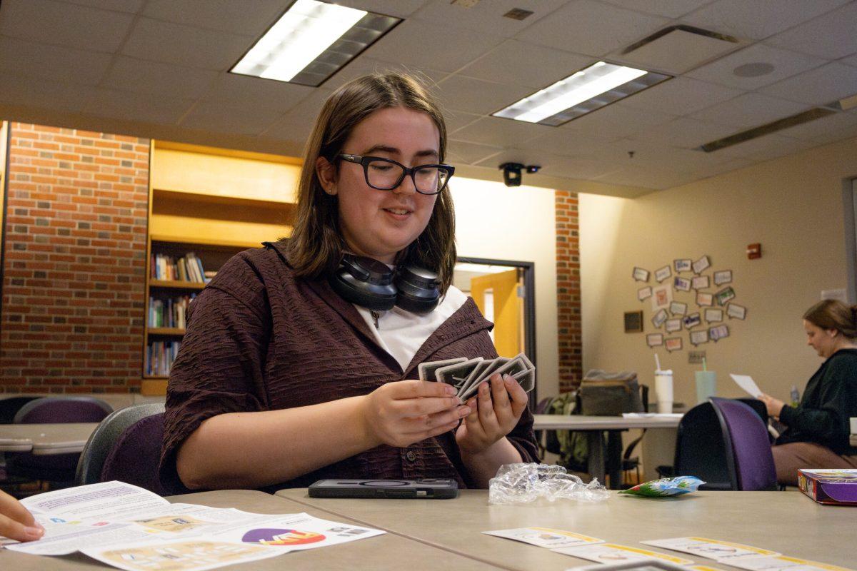 A student looks at eight cards in their hand.