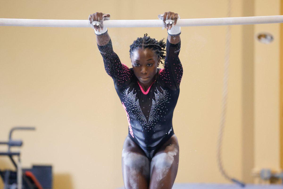 A Missouri gymnast swinging on the bars.