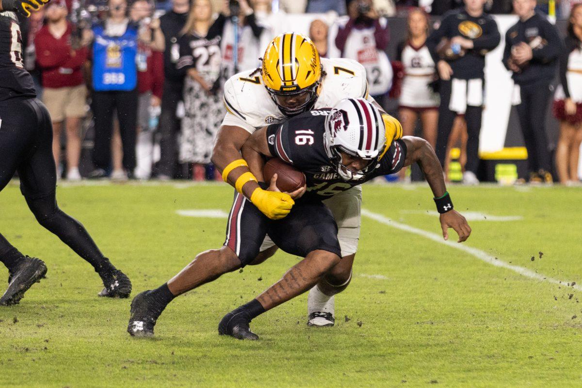 A Missouri football player sacking a South Carolina quarterback.