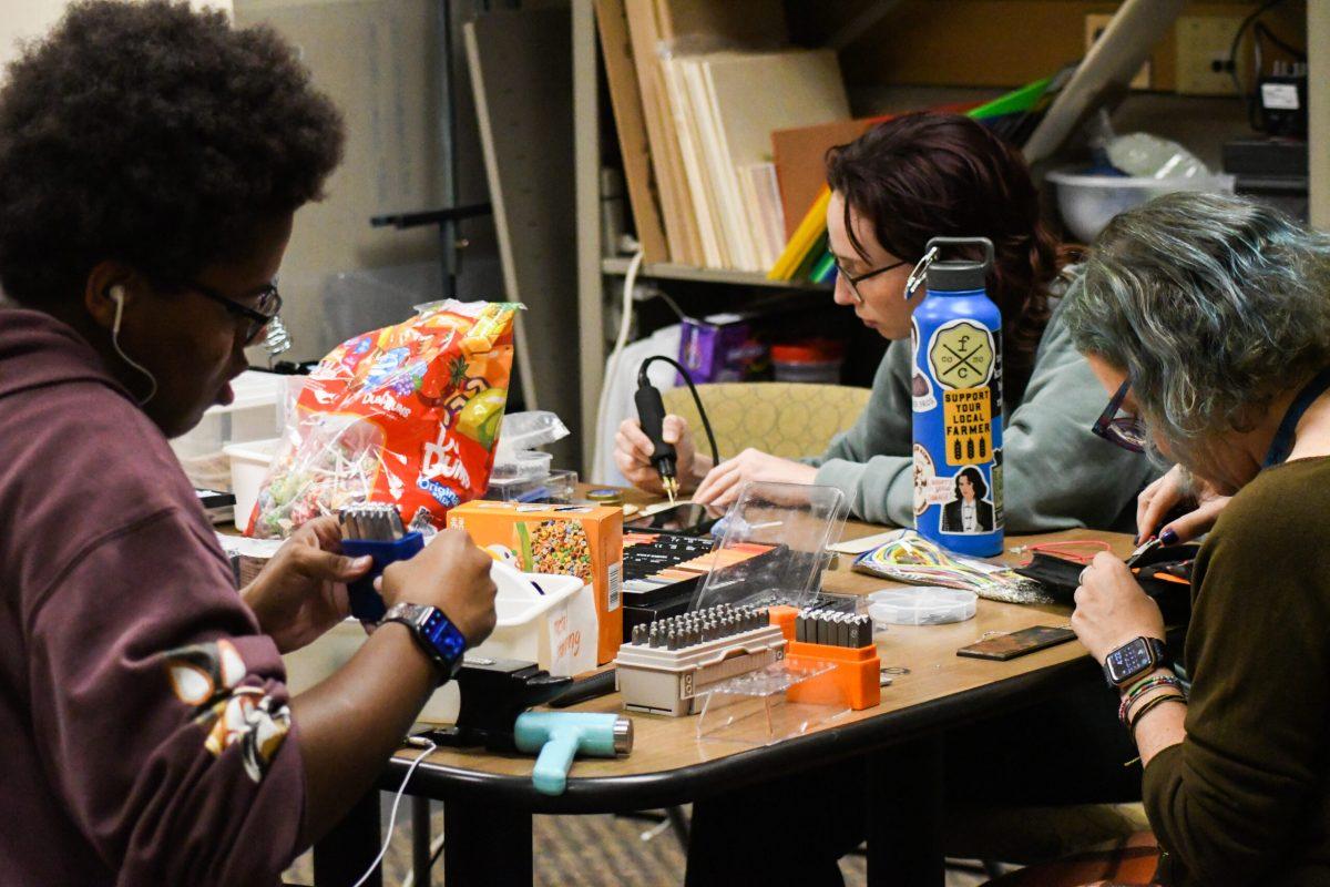 Attendees making various crafts around the table.