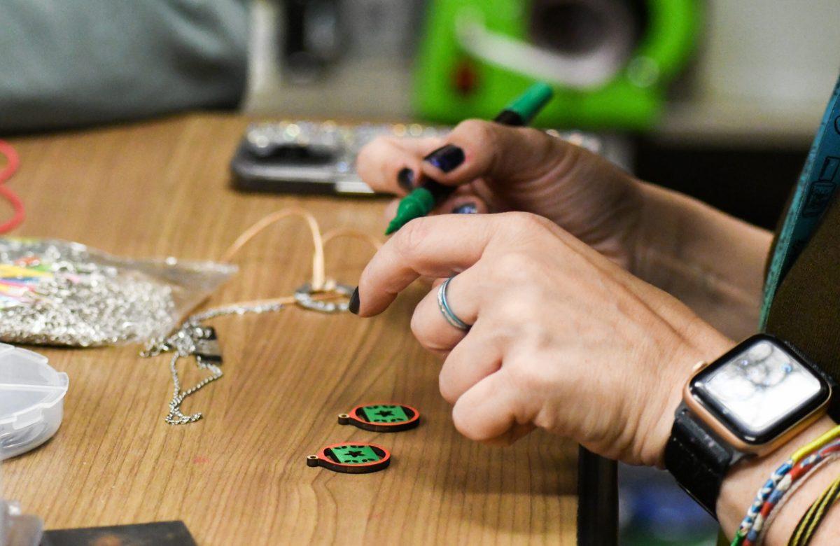 A person coloring wooden ornaments.