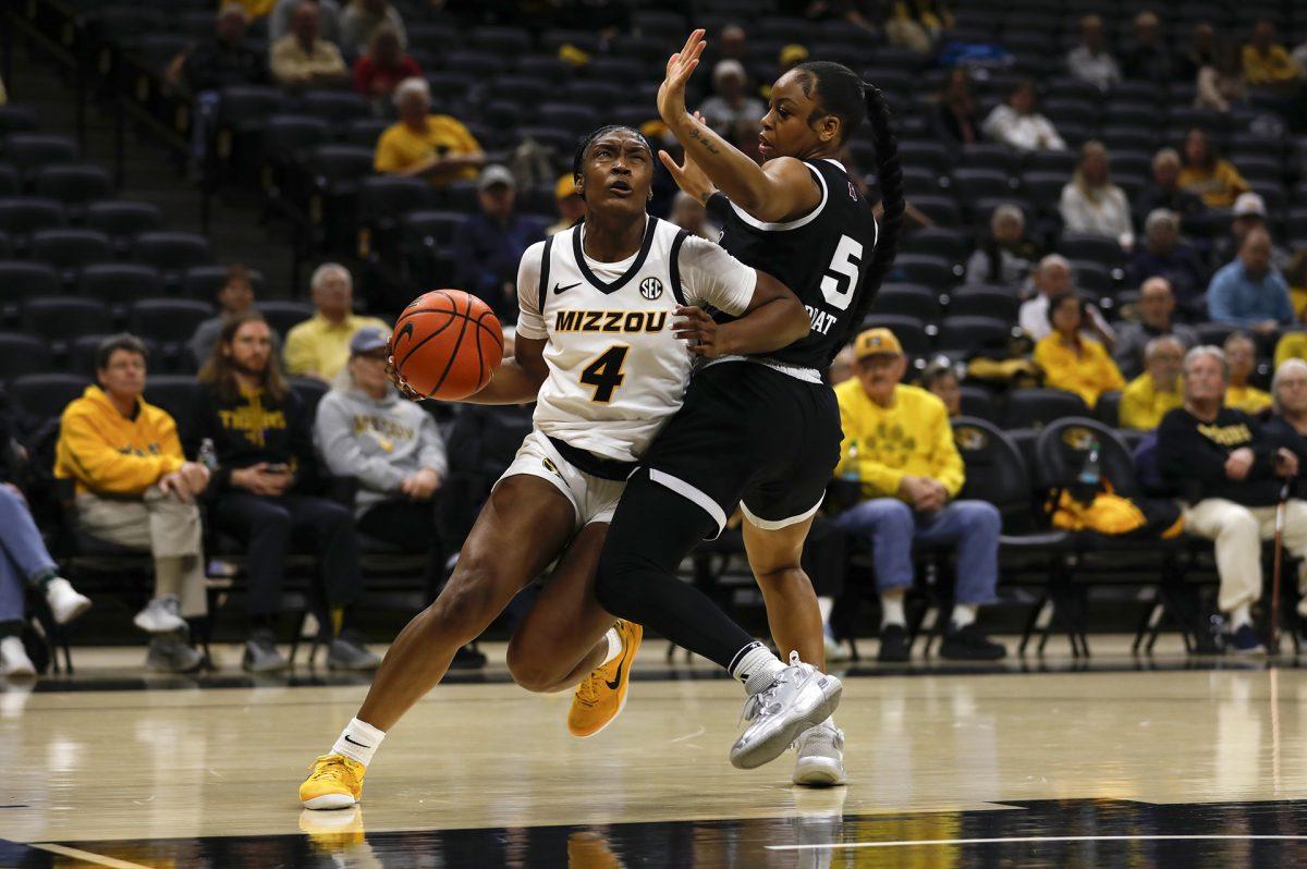A Missouri basketball player working against a defender.