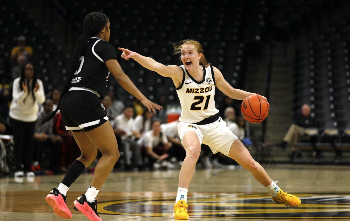 A Missouri basketball player shouting and pointing to her teammate.