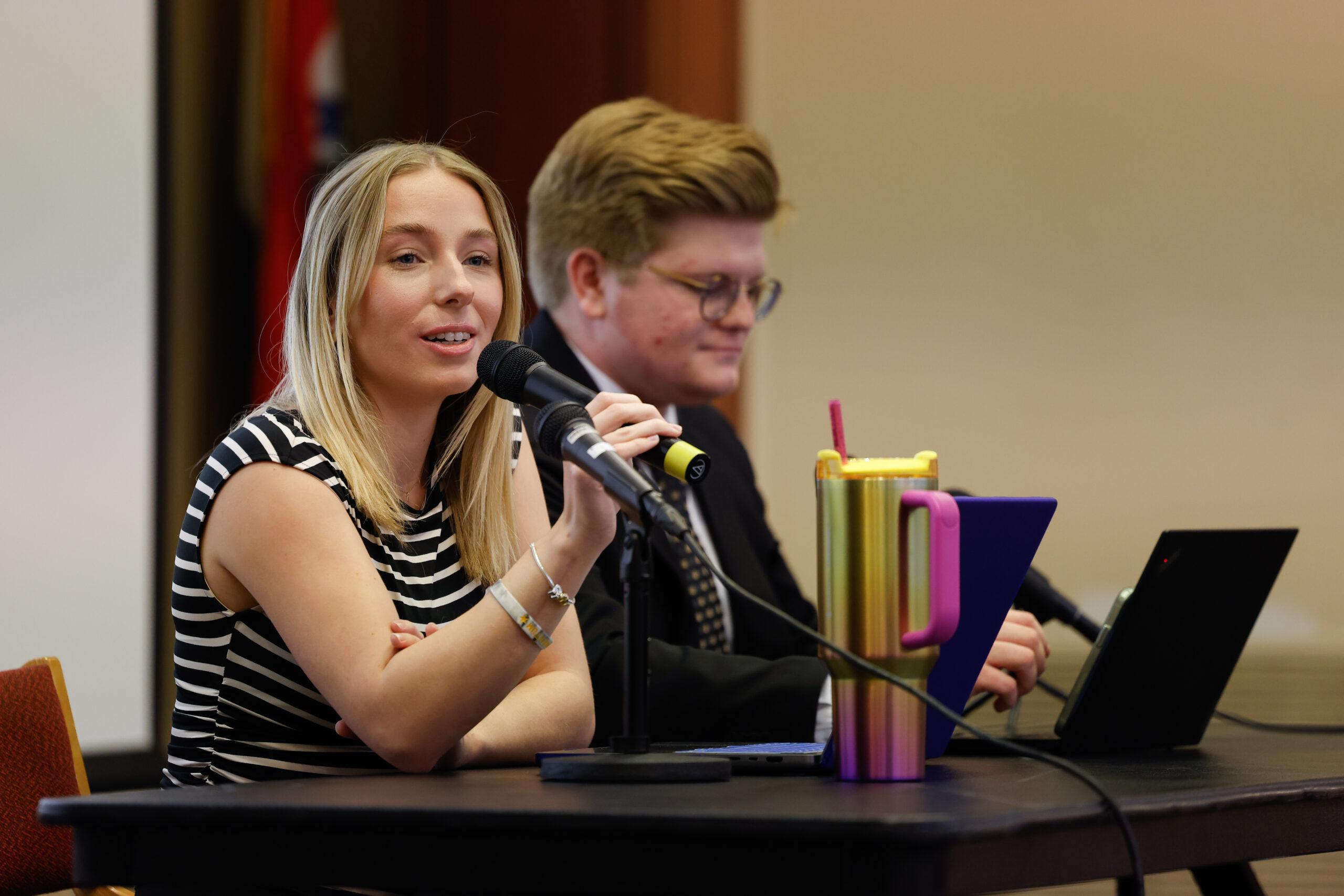 A woman speaks into a microphone.