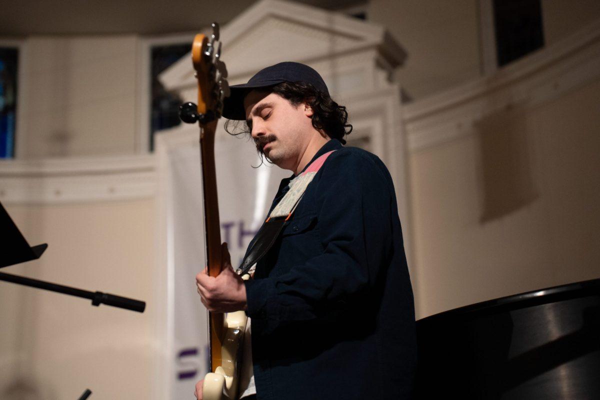 A guitarist performing on a stage.