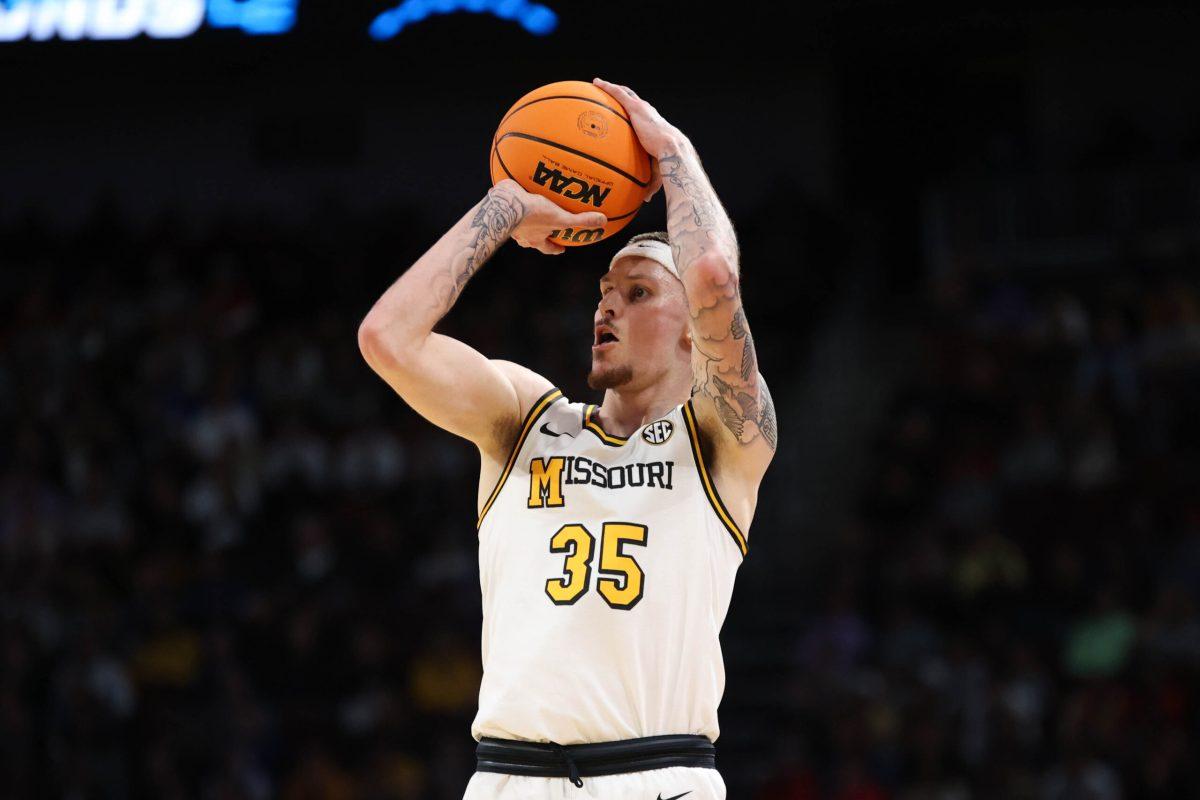A Missouri basketball player taking a 3-point shot.