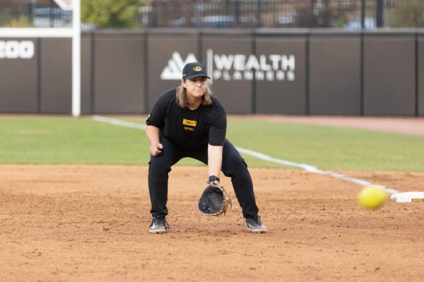 A softball player preparing to field the ball.