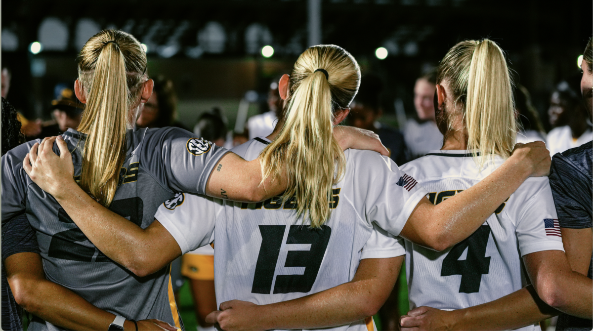Missouri women’s soccer players Morgan Meador, Callaway Combs, and Ava Vetter hold each other in celebration after their win over Texas on Sept. 12, 2025, at Walton Stadium in Columbia, Mo.