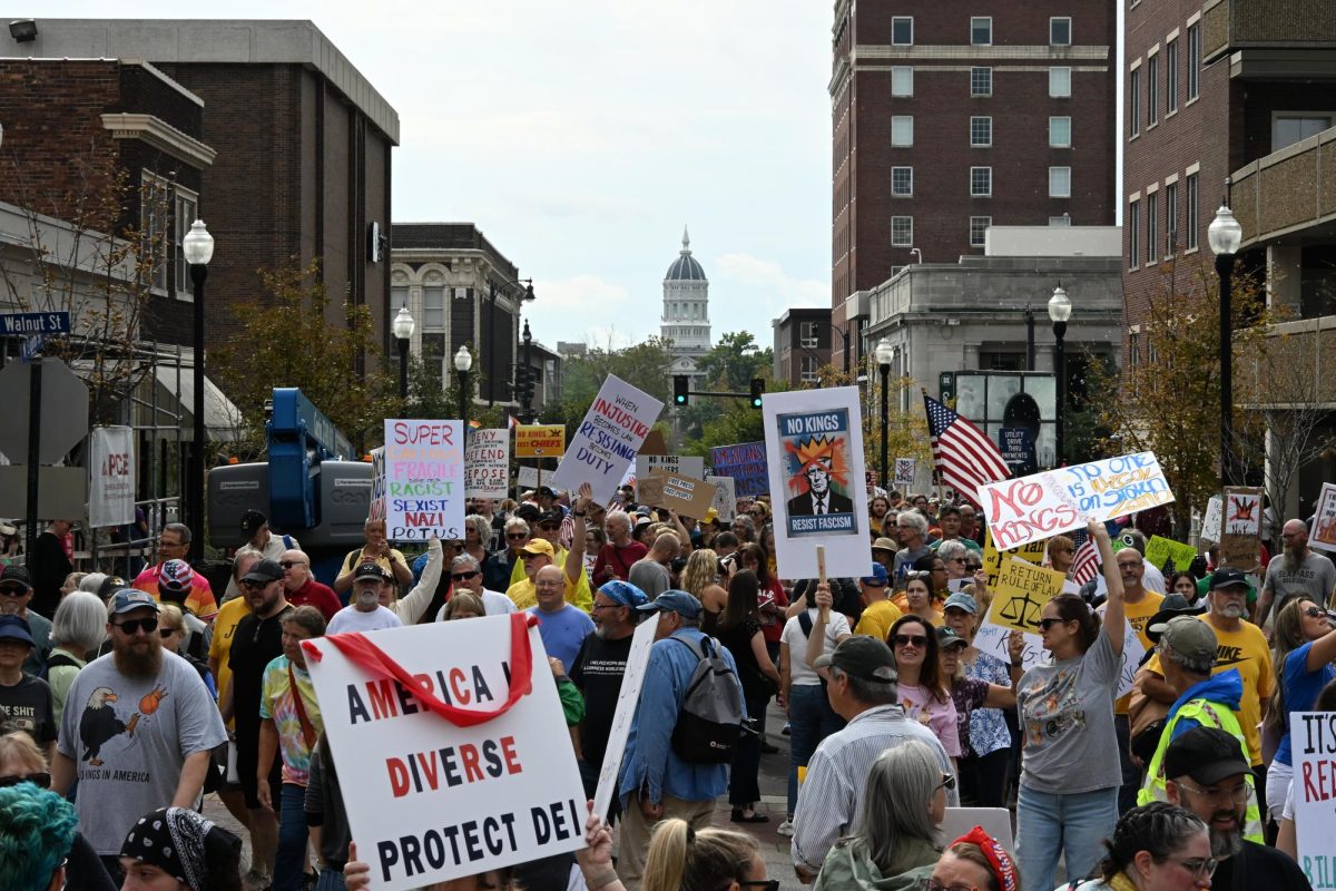 Hundreds of protesters stand outside the Boone County Courthouse just north of Jesse Hall on Saturday, Oct. 18 in Columbia, Mo. As the march concluded, protesters lingered on 8th St. cheering, connecting and signing petitions. 