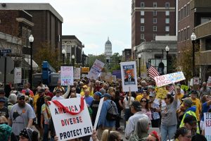 Hundreds of protesters stand outside the Boone County Courthouse just north of Jesse Hall on Saturday, Oct. 18 in Columbia, Mo. As the march concluded, protesters lingered on 8th St. cheering, connecting and signing petitions. 
