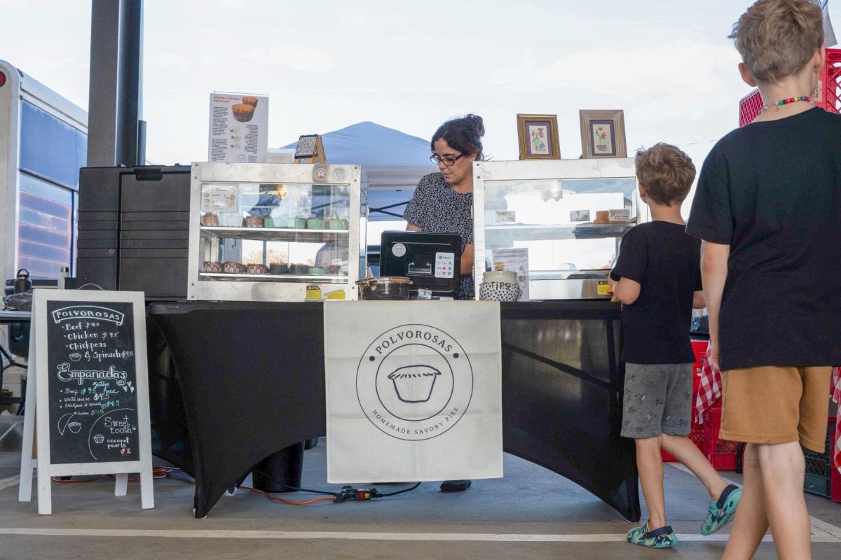 Christina Nunez, owner of Polvorosas Savory Pies, restocks empanadas at Columbia Farmers Market on Saturday, Nov. 15 in Columbia, Mo. Nunez sells a range of Venezuelan baked goods.