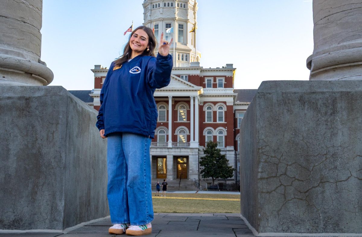 Josie Rempfer, Rockin’ Against Multiple Sclerosis (RAMS) Community Engagement and Rock-It director, holds up the RAMS hand-sign in front of Jesse Hall on Sunday, Feb. 15 in Columbia, Mo. RAMS holds events throughout the month of February to raise money for multiple sclerosis.