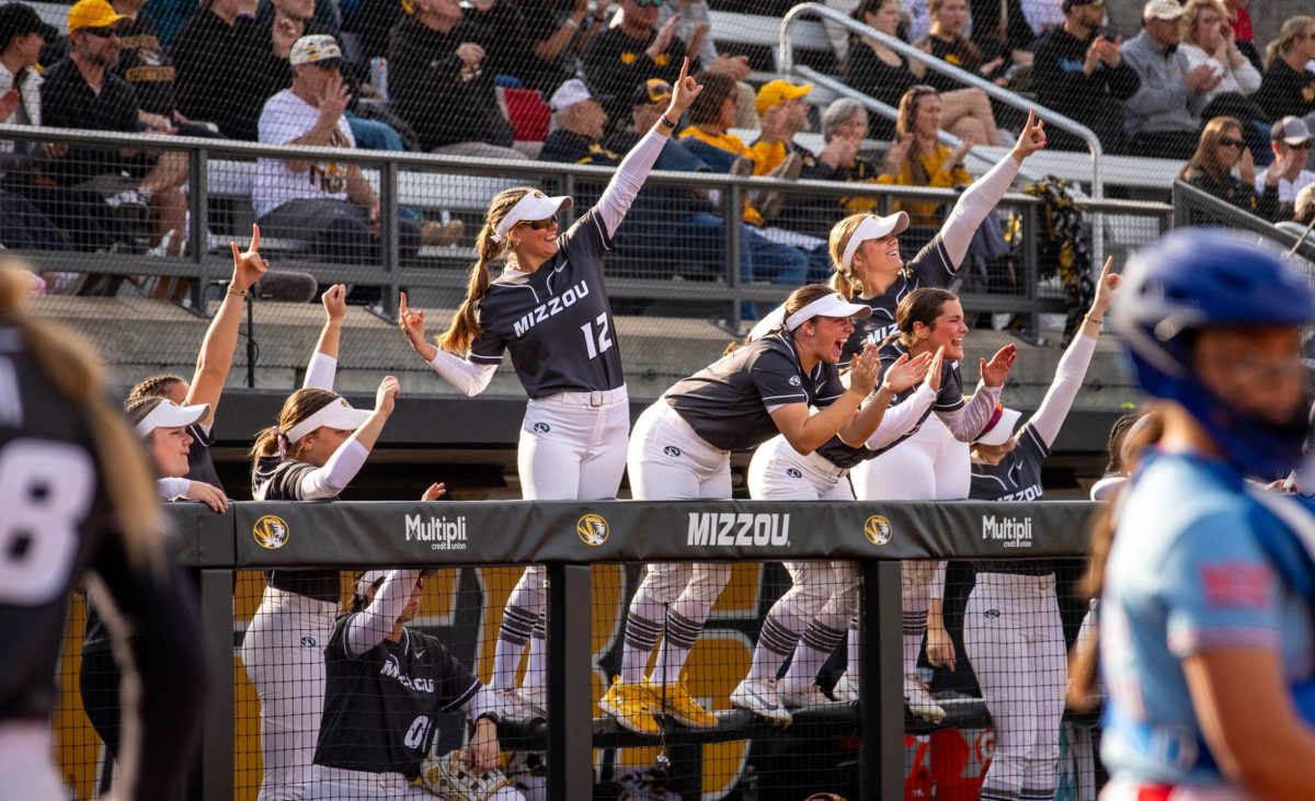 The Mizzou Softball team cheers on their team member at bat from the dugout during the Mizzou Invitational against Drake University on Feb. 28 at Mizzou Softball Stadium in Columbia. The team celebrated the batter hitting a double, causing junior  Abby Hay to run home and score for the Tigers.