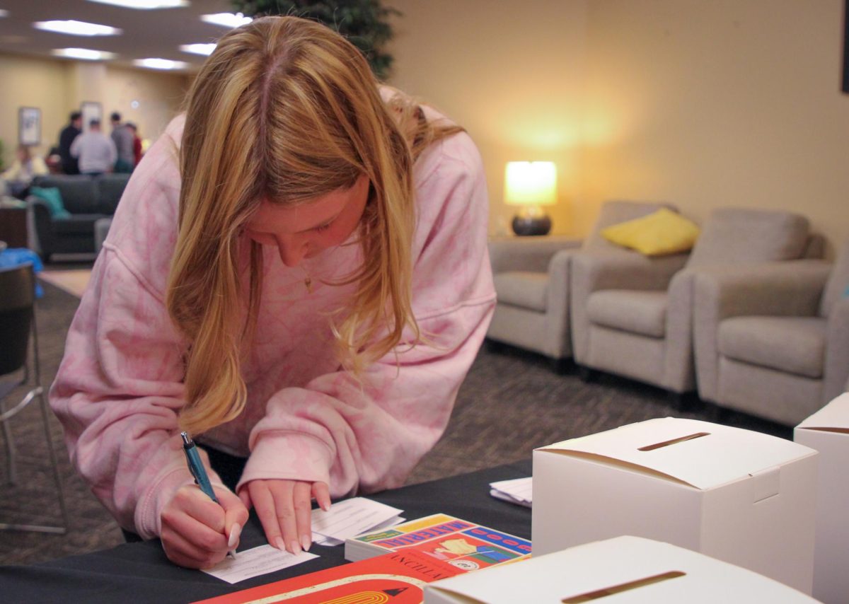 Senior Kristyn Schaller fills out a book raffle ticket in the Women’s Center on Wednesday, March 18 in Columbia, Mo. The Women’s Center raffled off books written by women to celebrate National Women’s History Month.
