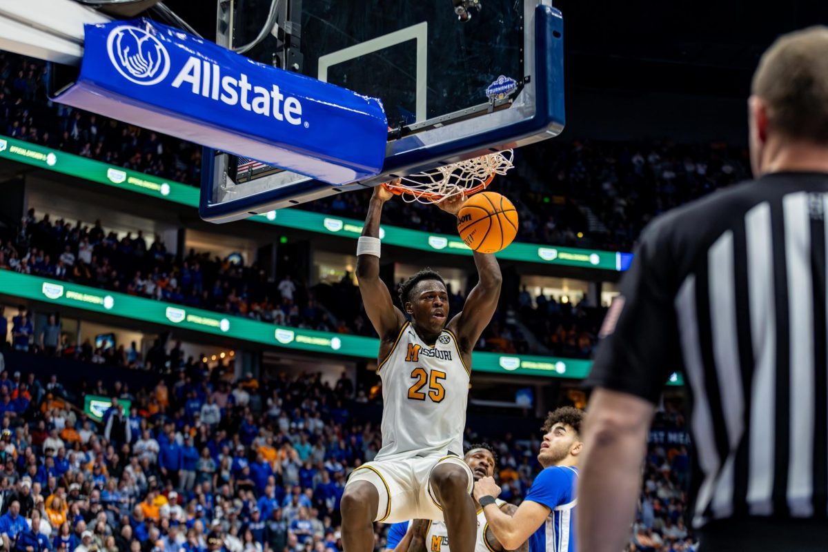 Missouri forward Mark Mitchell hangs on the basket after scoring in a game against Kentucky on Thursday, March 12, at Bridgestone Arena in Nashville, Tenn. Mitchell played for 39 minutes. 