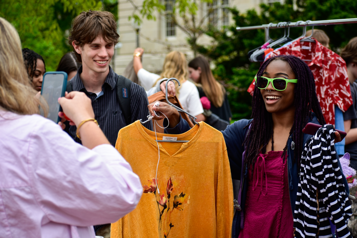 An event attendee poses for a photo on Wednesday, April 22, at Lowry Mall in Columbia, Mo. After counting their items, attendees were asked to take a photo with their items.