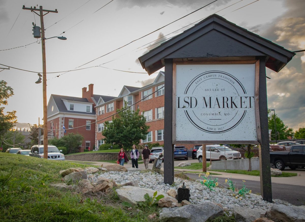 The Lee Street Deli Market sign in Columbia, Mo., stands under the partially cloudy sky as residents walk to the venue for the Music Factory Semester Sendoff on April 30. Despite delays due to the rain, live performances began at 7 p.m. and continued into the evening. 